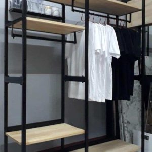 Estante de metal negro con baldas de madera clara, incluye barra para colgar ropa. Diseño moderno, ideal para organizar espacios en casa o tienda.