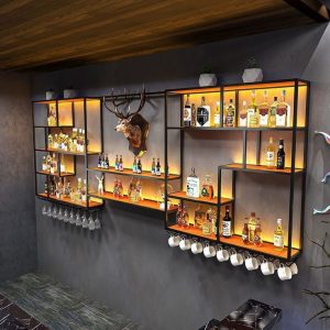 Estante moderno de metal y madera con iluminación LED, ideal para exhibir botellas y copas. Diseño en niveles, con espacio para colgar tazas, decorando una pared de bar en casa.