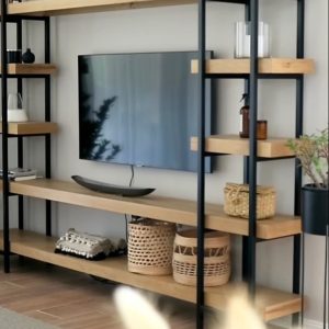 Estantería moderna de metal negro y madera clara, con varias baldas decoradas, alrededor de una televisión montada en la pared. Ideal para salón contemporáneo.