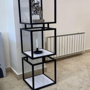 Estantería moderna de tres niveles con estructura cuadrada de metal negro y estantes blancos, perfecta para decoración contemporánea.