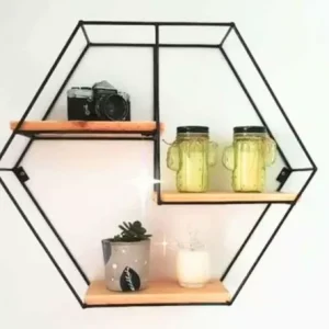 Estante hexagonal de metal negro con tres repisas de madera, decorado con cámara, tazas de vidrio y planta. Diseño moderno para organización y decoración del hogar.