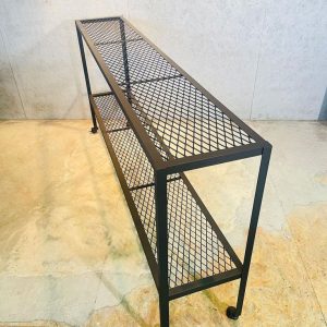 Estantería de metal de estilo industrial con diseño de rejilla, dos niveles y estructura rectangular negra, ideal para espacios modernos.