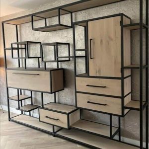 Estantería moderna con estructura de metal negro y paneles de madera clara. Diseño geométrico, con estantes y cajones de diversos tamaños. Ideal para almacenamiento y decoración.