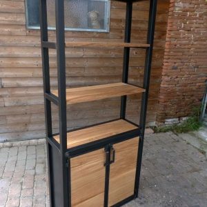 Estantería de metal negro y madera, con dos baldas abiertas y un armario inferior de puertas dobles. Diseño industrial ideal para organizar y decorar espacios interiores.