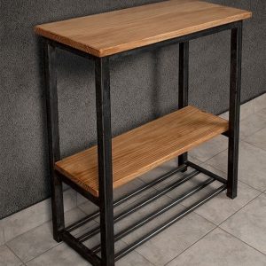 Mesa alta de madera con marco de metal negro, con estante inferior. Estilo industrial, ideal para espacios modernos y funcionales. Superficie y estante de color claro.