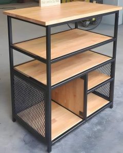 Mueble de estantería con estructura metálica negra y baldas de madera. Incluye paneles laterales de malla y un compartimento con puerta, combinando estilo industrial y funcionalidad.