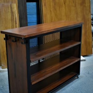 Mueble de madera con estructura metálica negra, tres estantes abiertos y ruedas. Diseño industrial, ideal para almacenamiento o exhibición en interiores modernos.