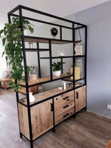 Estantería moderna de madera y metal negro, con múltiples niveles y compartimentos, ideal para decoración y almacenamiento en salones o despachos.