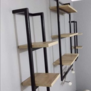 Estantería de pared moderna con estructura metálica negra y estantes de madera clara. Diseño geométrico y minimalista, ideal para decoración contemporánea.