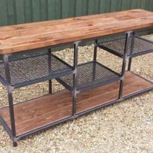 Mesa de trabajo industrial con estructura metálica negra y estantes de madera. Superficie amplia de madera, con tres niveles de almacenamiento, ideal para talleres o garajes.