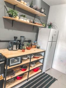 Estante de cocina abierto con estructura de metal negro y repisas de madera, utilizado para almacenamiento de electrodomésticos y utensilios de cocina.