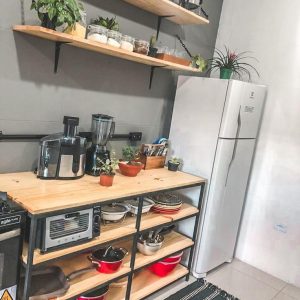 Estante de cocina abierto con estructura de metal negro y repisas de madera, utilizado para almacenamiento de electrodomésticos y utensilios de cocina.