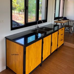 Gabinete de cocina con superficie negra brillante, cuerpo de madera clara y estructura metálica negra, que integra un fregadero en un diseño moderno y funcional.