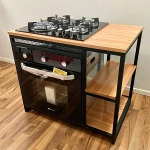 Mueble de cocina con encimera de madera, estufa empotrada de gas con cuatro quemadores y horno integrado. Incluye estantes laterales abiertos para almacenamiento adicional. Diseño moderno y funcional.