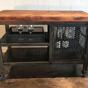 Carro de bar industrial con estructura metálica negra, encimera de madera, estantes abiertos, compartimento de rejilla y ruedas. Ideal para almacenamiento y exhibición de botellas y copas.