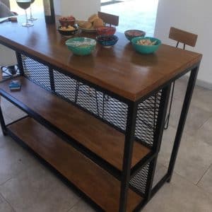 Mesa alta de madera con estructura metálica negra, dos estantes de rejilla y diseño moderno. Ideal para espacio de comedor o cocina.