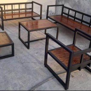 Juego de muebles de jardín con estructura de metal negro y tablones de madera. Incluye sofá, sillón y mesas de centro y lateral, ideal para exteriores. Diseño moderno y minimalista.