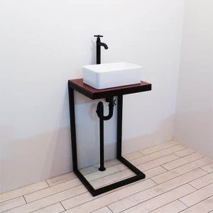 Lavabo moderno con base de metal negro, encimera de madera oscura y lavabo blanco rectangular. Grifo negro elegante. Diseño minimalista y compacto ideal para espacios pequeños.