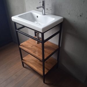 Lavabo moderno con estructura metálica negra, lavabo blanco rectangular y dos estantes de madera rústica, ideal para baños de estilo minimalista e industrial.