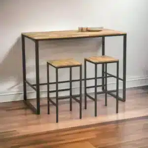 Mesa alta y dos taburetes de estilo industrial. Estructura de metal negro y superficies de madera clara. Diseño minimalista ideal para comedores pequeños.