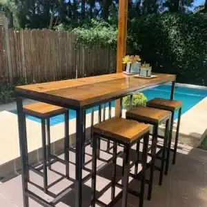 Conjunto de mueble de madera y metal con mesa alta rectangular y taburetes cuadrangulares, perfecto para exteriores. Ideal para reuniones junto a la piscina o en el jardín.