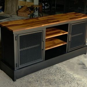 Mueble tipo aparador de estilo industrial, con estructura metálica negra, puertas de rejilla y superficie de madera pulida. Incluye estantes centrales de madera ajustables.