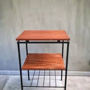 Mesa auxiliar de madera con estructura metálica negra, dos niveles rectangulares y una rejilla inferior. Ideal para almacenamiento o decoración en interiores modernos.