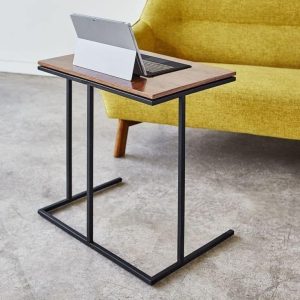 Mesa auxiliar moderna con estructura metálica negra y superficie de madera. Ideal para espacios pequeños o para usar junto a un sofá. Diseño funcional y elegante.