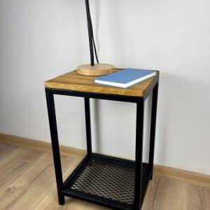 Mesa auxiliar moderna con estructura metálica negra, superficie de madera clara y estante inferior de rejilla.