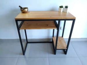 Mesa de madera clara con estructura de metal negro, incluye dos niveles y un estante lateral. Ideal para espacios modernos y minimalistas.