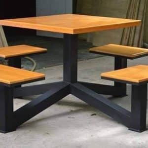 Mesa cuadrada de madera con base metálica negra y cuatro asientos integrados del mismo material y diseño. Ideal para exteriores o áreas de descanso. Diseño moderno y funcional.