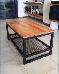 Mesa de centro de madera y metal con estante inferior de rejilla negra. Diseño moderno e industrial, ideal para sala de estar.