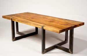 Mesa de comedor moderna con tablero de madera maciza y patas de metal en forma de U, diseño industrial y acabado natural. Ideal para espacios contemporáneos.