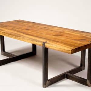 Mesa de comedor moderna con tablero de madera maciza y patas de metal en forma de U, diseño industrial y acabado natural. Ideal para espacios contemporáneos.