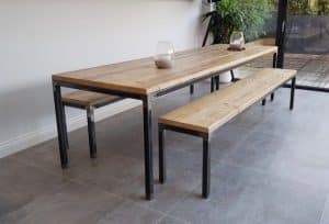 Mesa de comedor y banco de madera con estructura metálica negra, estilo industrial. Diseño minimalista y contemporáneo, ideal para interiores modernos y espacios amplios.