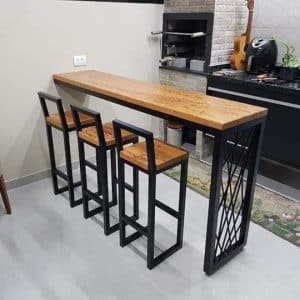 Barra alta de madera con estructura metálica negra, acompañada de tres taburetes a juego. Diseño moderno y elegante, ideal para cocina o bar en el hogar.