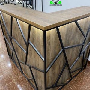 Mostrador en forma de L con top de madera y estructura metálica con diseño geométrico. Ideal para recepciones o mostradores de atención.