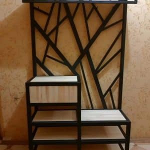Estantería moderna con estructura de metal negro y diseño geométrico asimétrico. Cuenta con múltiples estantes de madera clara para almacenamiento o decoración. Ideal para espacios contemporáneos.