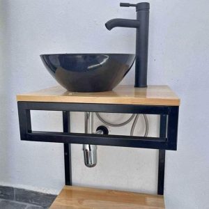 Lavabo moderno con encimera de madera clara, estructura metálica negra, lavamanos redondo negro y grifo a juego. Diseño minimalista y funcional, ideal para baños contemporáneos.