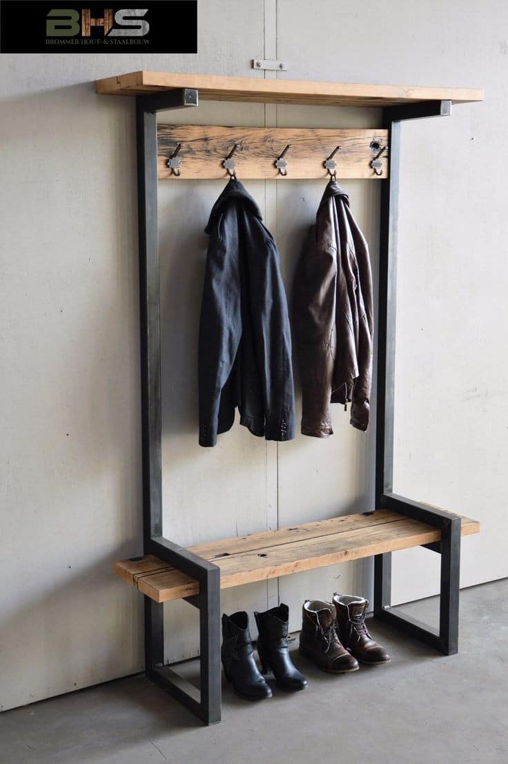 Mueble de entrada industrial de metal negro y madera, con banco, perchas para abrigos y espacio para zapatos; diseño moderno y funcional ideal para recibidores.