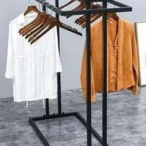 Perchero independiente de metal negro con estante superior, ideal para ropa y accesorios. Incluye espacio para colgar prendas con perchas. Diseño moderno y funcional para organización.