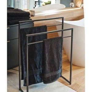 Toallero de metal negro con diseño minimalista de tres barras, mostrando toallas colgadas. Perfecto para baños modernos.