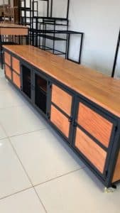 Gabinete largo de madera y metal, con puertas de rejilla negra y paneles de madera clara. Diseño industrial, ideal para almacenamiento en salas o comedores modernos.