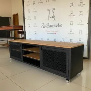 Mueble TV moderno de metal negro y madera, con estantes abiertos y puertas de rejilla, montado sobre ruedas para fácil movilidad. Ideal para sala de estar contemporánea.