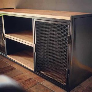 Mueble de almacenamiento de diseño industrial con base de madera y estructura de metal. Puerta con rejilla metálica y estantes abiertos, ideal para espacios modernos y funcionales.