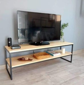 Mueble para TV de estilo industrial, con estructura de metal negro y dos superficies de madera clara. Ideal para almacenar dispositivos electrónicos y decoración. Diseño moderno y funcional.