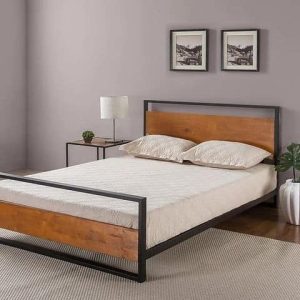 Cama con estructura de metal negro y cabecero de madera, acompañada de una mesita con lámpara. Diseño minimalista y moderno, ideal para un dormitorio elegante y acogedor.