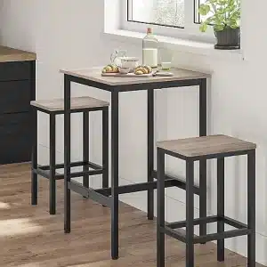 Conjunto de mesa alta y dos taburetes con estructura de metal negro y superficie de madera clara, ideal para cocinas pequeñas o espacios modernos y minimalistas.