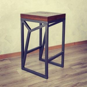 Taburete moderno con un asiento de madera cuadrado y base de metal negro con diseño geométrico. Ideal para decoración contemporánea o industrial.