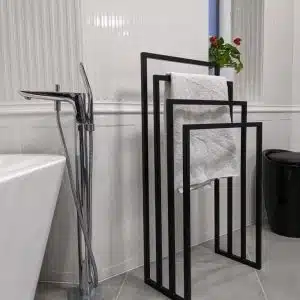Toallero de metal negro con diseño minimalista geométrico, compuesto por tres barras de diferentes tamaños, ideal para baños modernos.